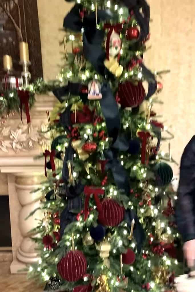 Decorated Christmas tree with red, gold ornaments and lights for holiday decor.