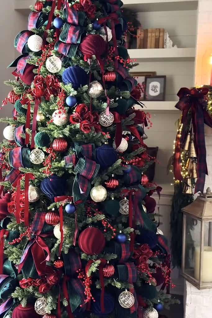 Colorful Christmas tree with ribbons, ornaments, and bows for holiday decor.