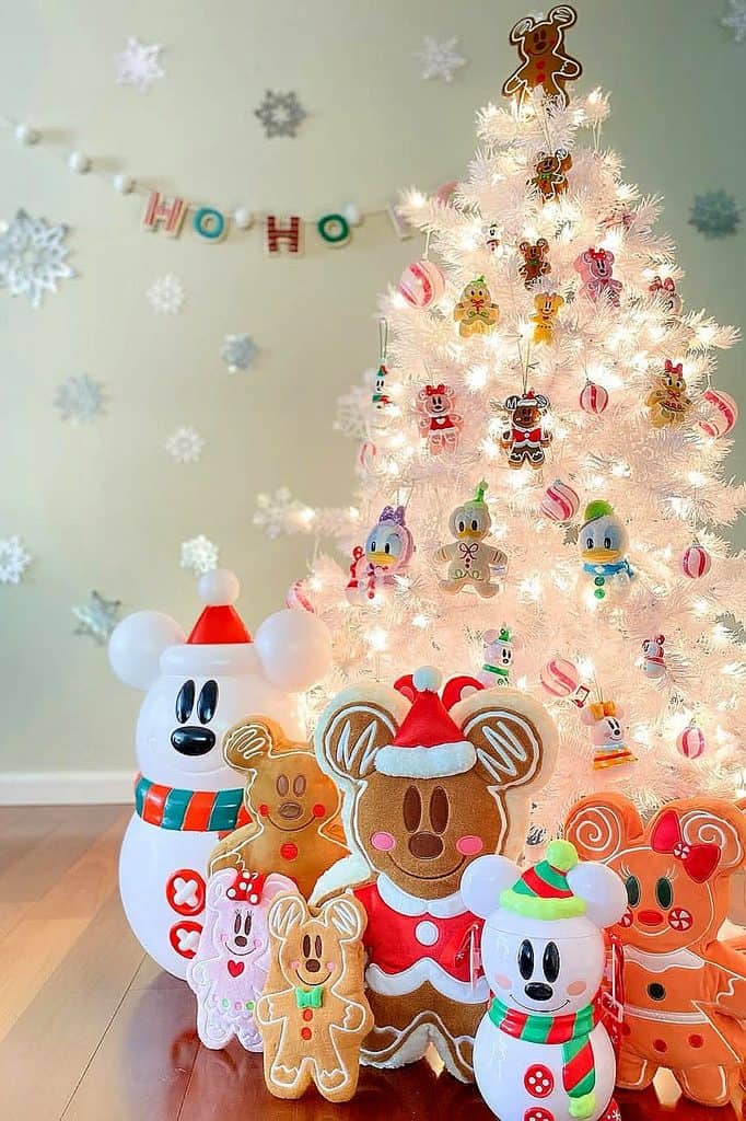 White Christmas tree decorated with Disney holiday ornaments and plush toys.