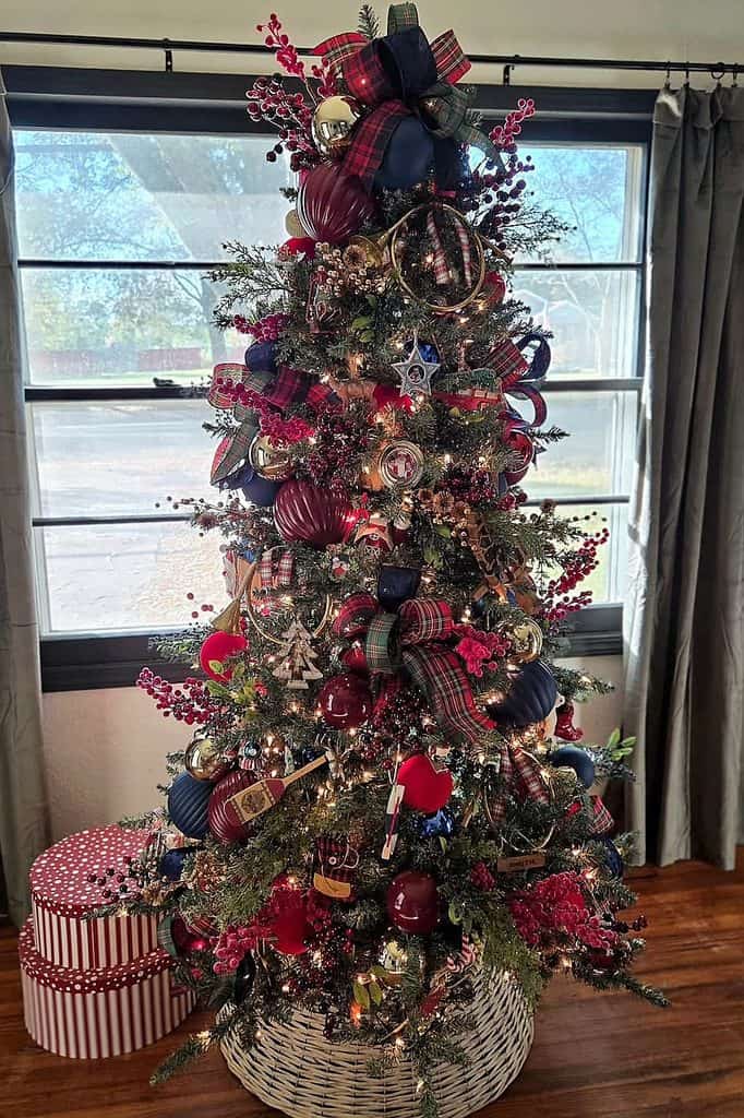 Decorated Christmas tree with red, navy, and plaid ornaments and ribbons.