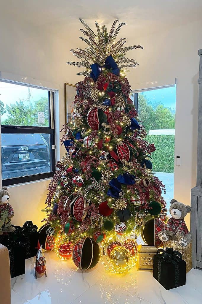 Elegant Christmas tree decorated with red, blue, gold ornaments and ribbons.