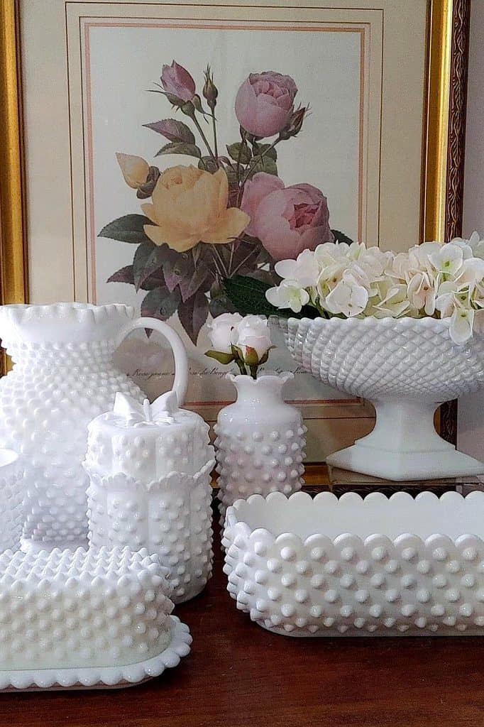 Elegant collection of white milk glass vases and bowls with floral artwork.