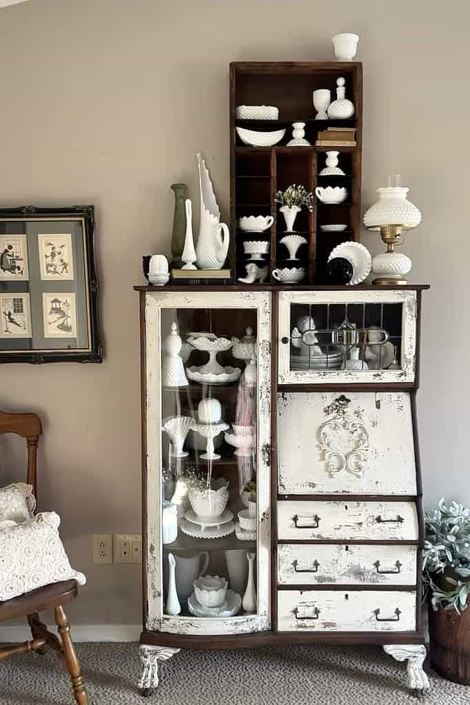 Vintage white milk glass collection displayed in a rustic cabinet with shelves.