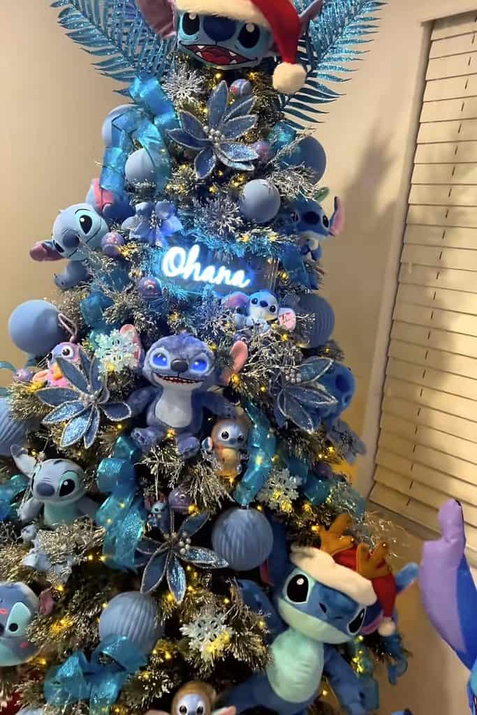 Colorful Disney-themed Christmas tree with Stitch and Lilo ornaments and blue accents.