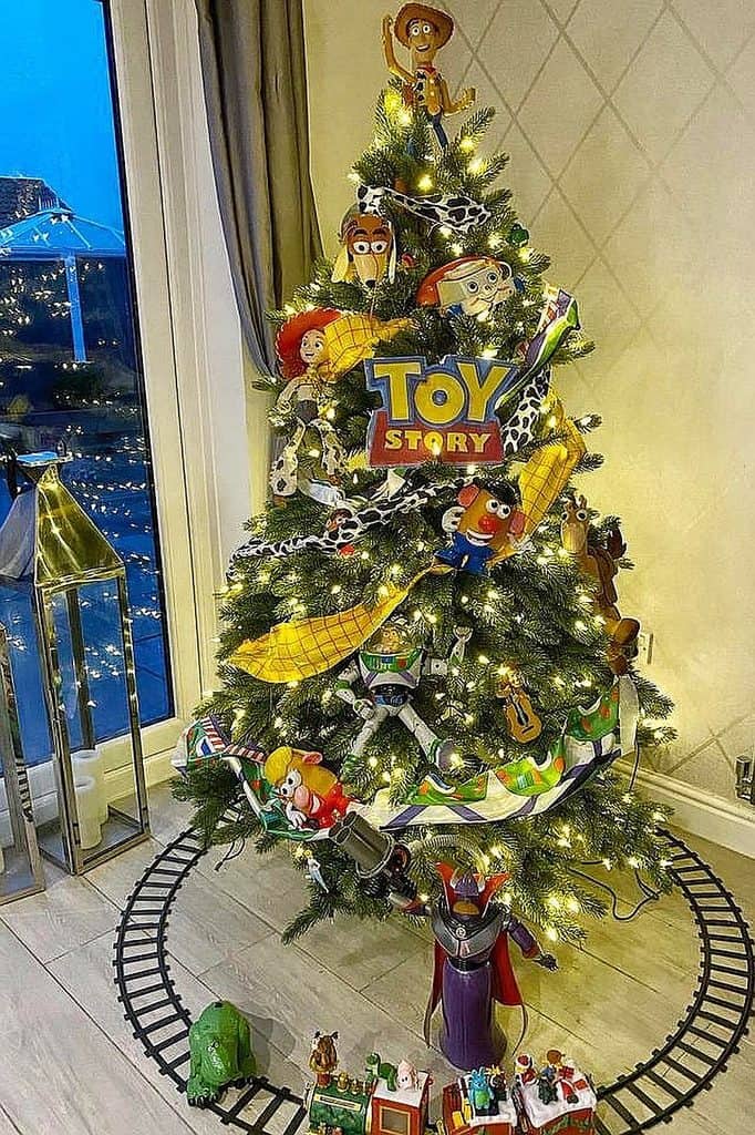 Christmas tree decorated with Toy Story characters and lights in living room.