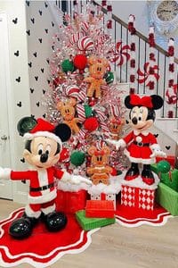 Colorful Disney-themed Christmas tree with Mickey and Minnie Mouse figures and gingerbread ornaments.