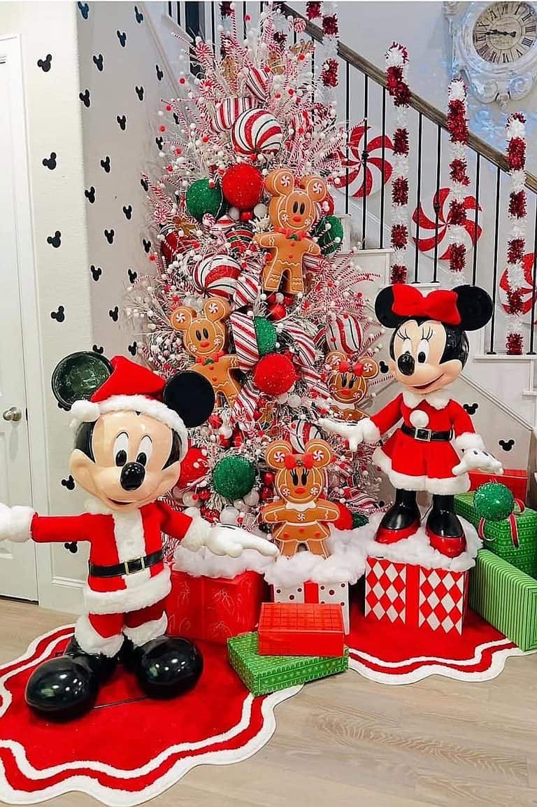 Colorful Disney-themed Christmas tree with Mickey and Minnie Mouse figures and gingerbread ornaments.