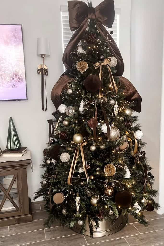 Beautiful Christmas tree with brown ribbons and gold ornaments for cozy holiday decor.