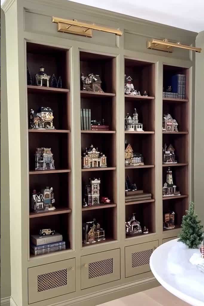 Miniature Christmas village displays in a built-in bookshelf for holiday decor.