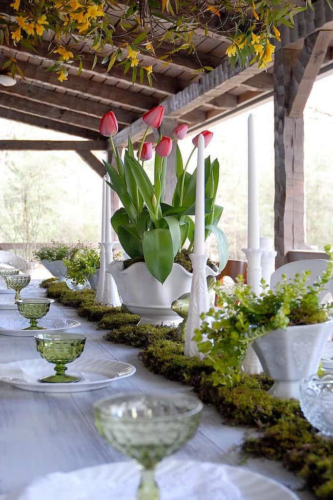 Beautiful tulip arrangement in a white vase on a charming table setting.
