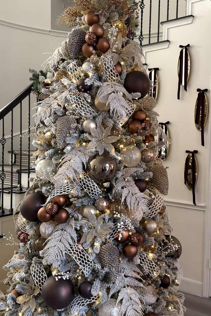 Cozy Christmas tree decorated with brown, gold, and silver ornaments and ribbons.